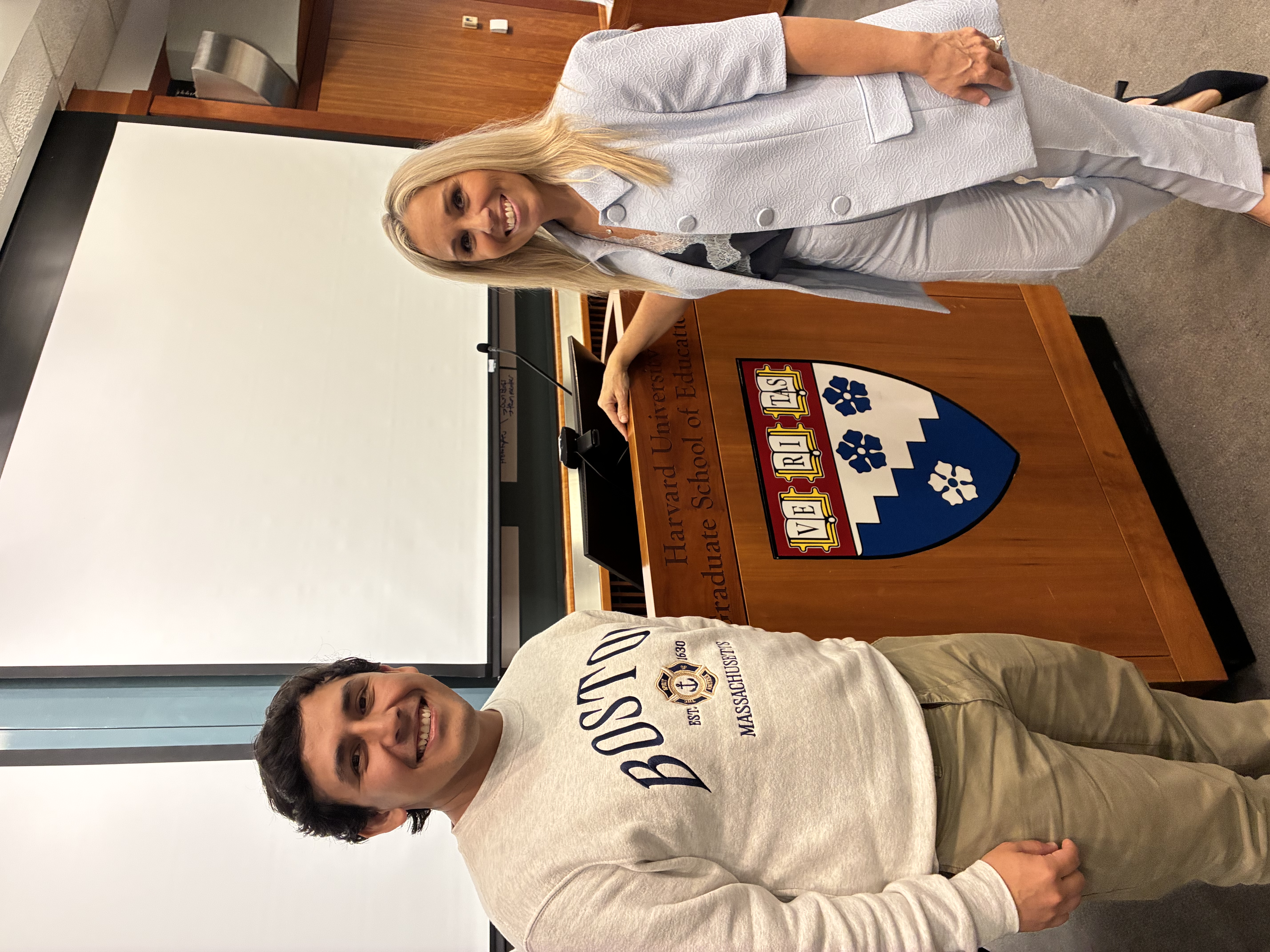 Anna DiGilio and Martín Sosa beside a wooden lectern in a lecture room